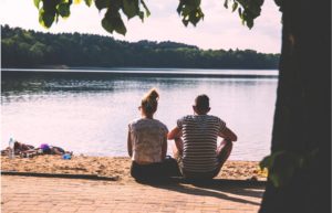 夫婦が湖の前で座っている画像